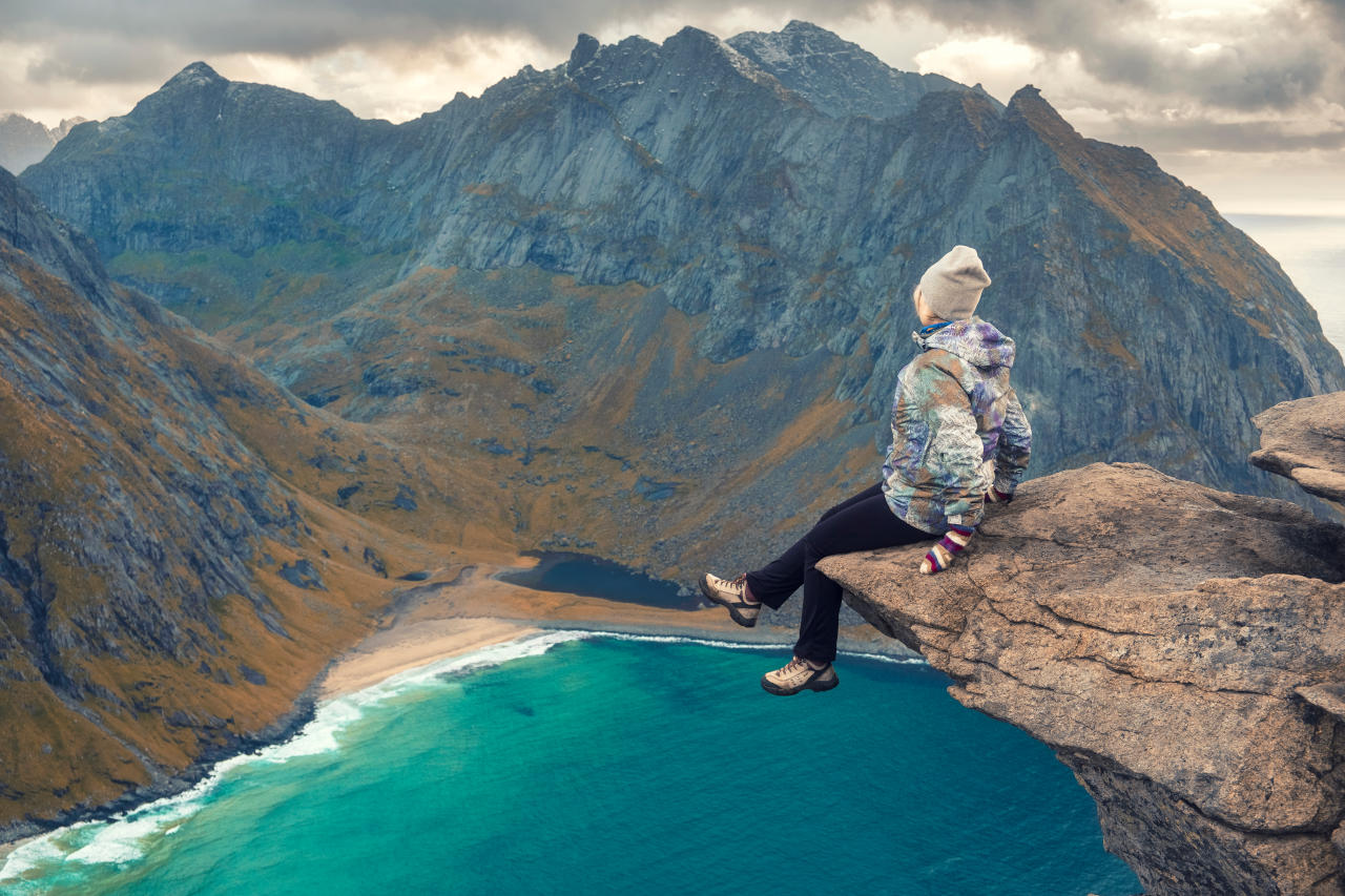 Når hypnose har fjernet fobien. Kvinde sidder på bjergskråning ved sø.